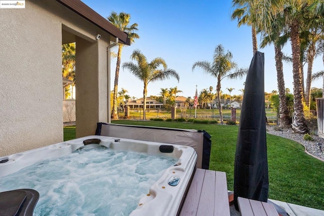 wooden terrace with a yard and a covered hot tub