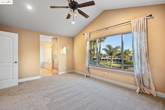 spare room with ceiling fan, vaulted ceiling, and light carpet