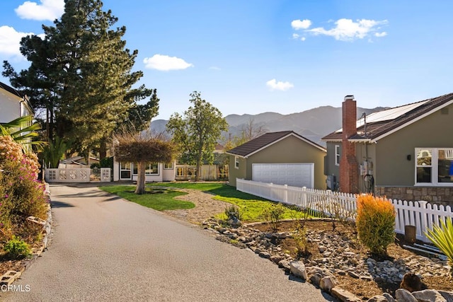 single story home featuring a mountain view, a garage, and solar panels