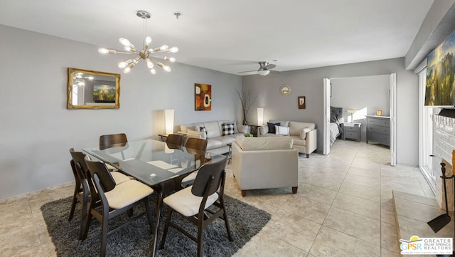 tiled dining room featuring ceiling fan with notable chandelier