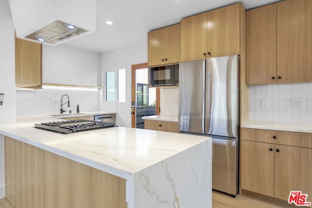 kitchen featuring stainless steel appliances, light stone countertops, sink, and custom range hood