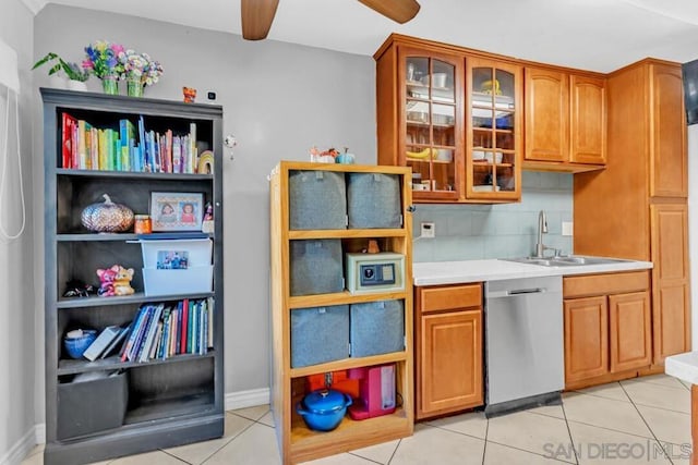 kitchen with tasteful backsplash, sink, stainless steel dishwasher, and light tile patterned flooring