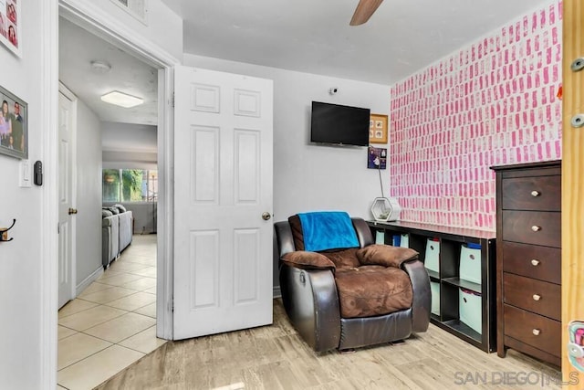 sitting room with wood-type flooring and ceiling fan