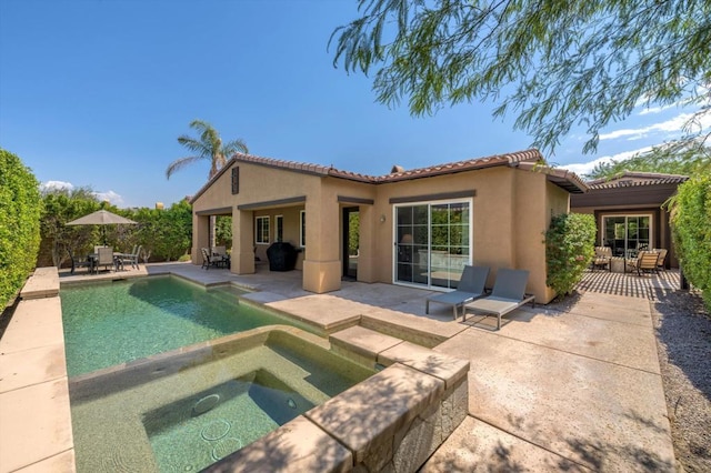 back of house with a swimming pool with hot tub, a pergola, and a patio