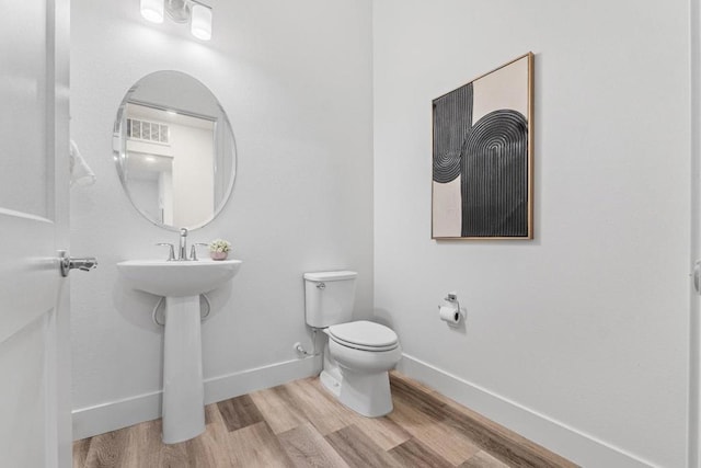 bathroom with hardwood / wood-style flooring and toilet