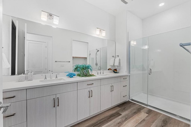 bathroom with a shower with door, wood-type flooring, and vanity