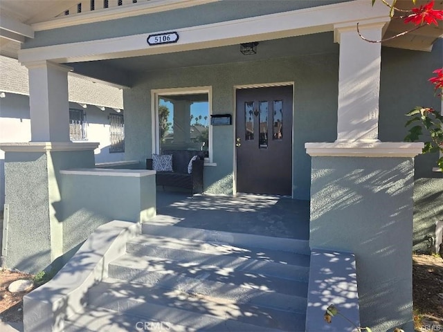 view of exterior entry featuring covered porch