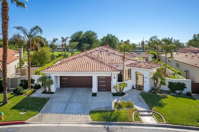 mediterranean / spanish-style home featuring a garage and a front yard