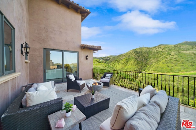 view of patio featuring a mountain view and an outdoor living space with a fire pit