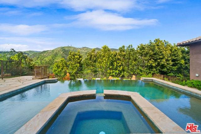 view of pool featuring an in ground hot tub and a mountain view