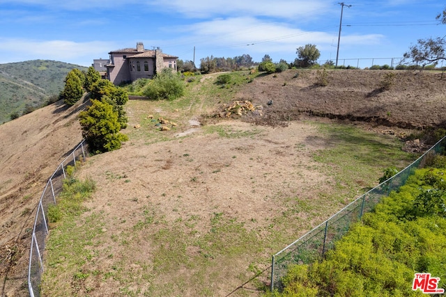 view of yard with a mountain view and a rural view