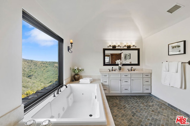 bathroom with vanity, a bathtub, and lofted ceiling