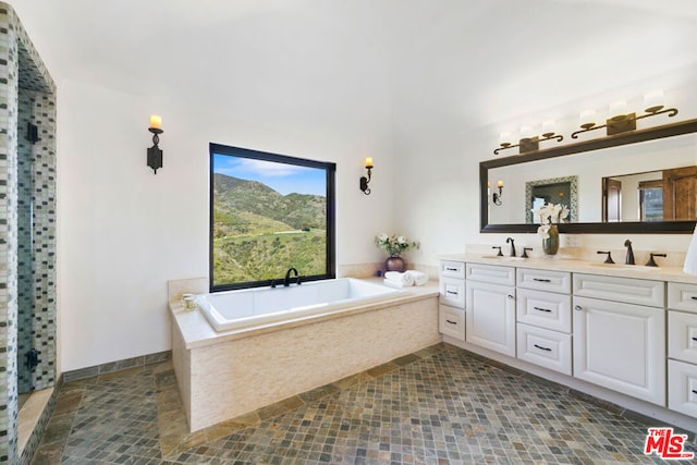 bathroom with tiled tub and vanity