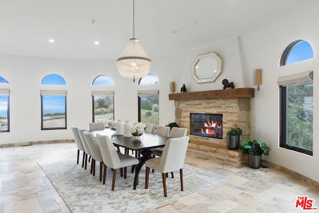 dining room with plenty of natural light, a towering ceiling, and a fireplace