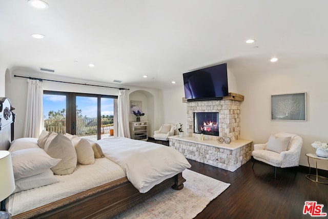 bedroom with a fireplace, access to exterior, and hardwood / wood-style floors