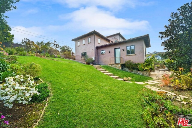 rear view of property featuring a lawn