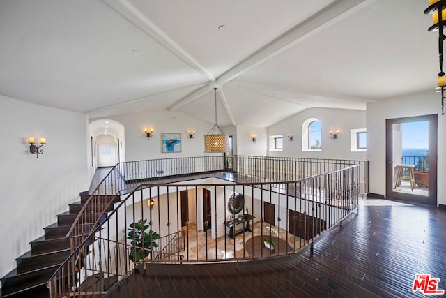 stairway with lofted ceiling with beams and hardwood / wood-style floors