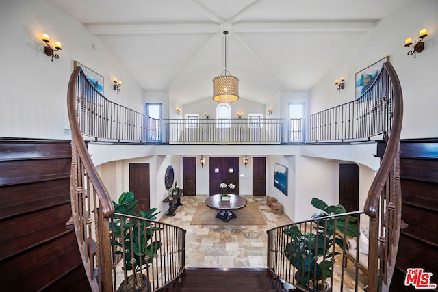 stairs featuring a notable chandelier, wood-type flooring, high vaulted ceiling, and beamed ceiling