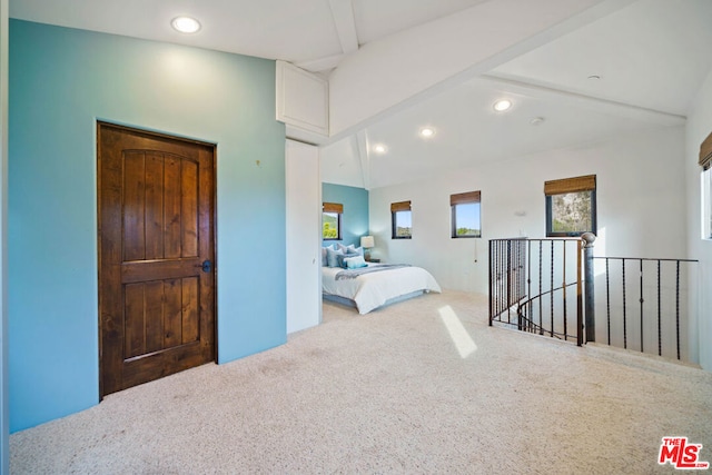 carpeted bedroom with lofted ceiling