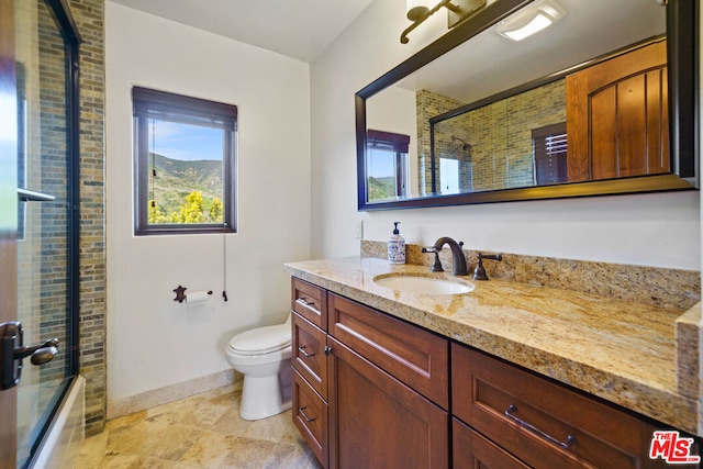 full bathroom featuring vanity, shower / bath combination with glass door, and toilet