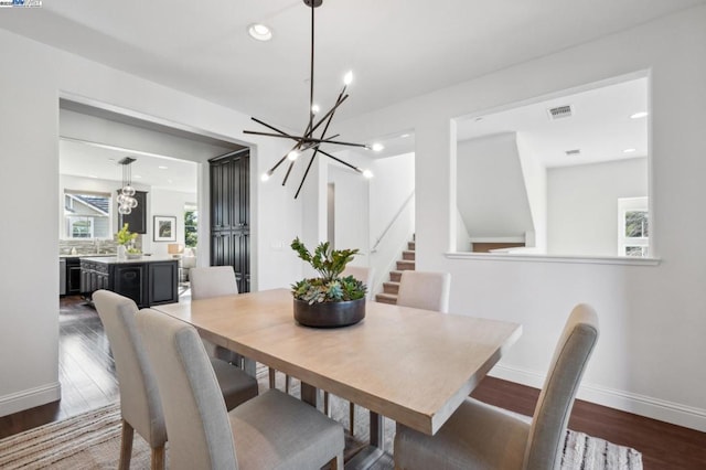 dining area with a notable chandelier and dark wood-type flooring