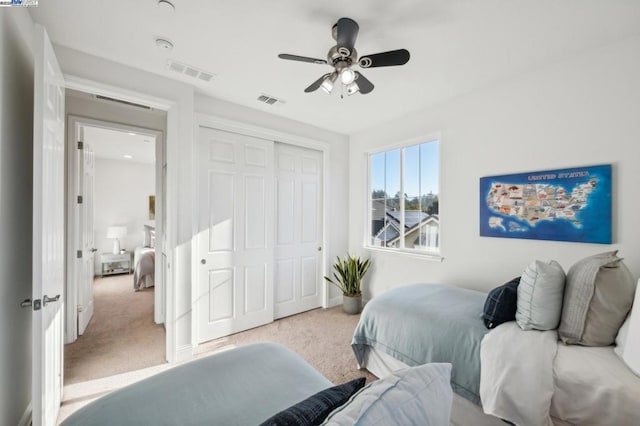 carpeted bedroom with ceiling fan and a closet