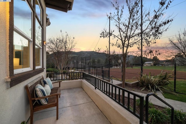 balcony at dusk featuring a mountain view