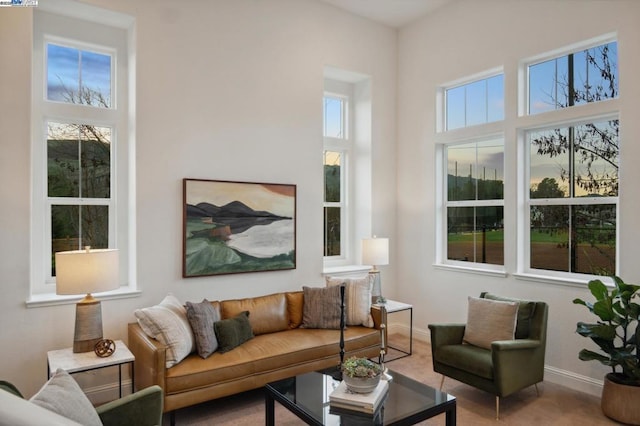 carpeted living room featuring a towering ceiling and plenty of natural light