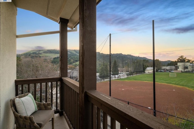 balcony at dusk featuring a mountain view