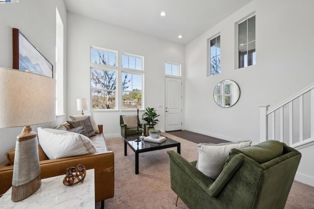 carpeted living room featuring a high ceiling