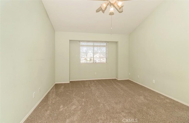 carpeted spare room featuring lofted ceiling and ceiling fan