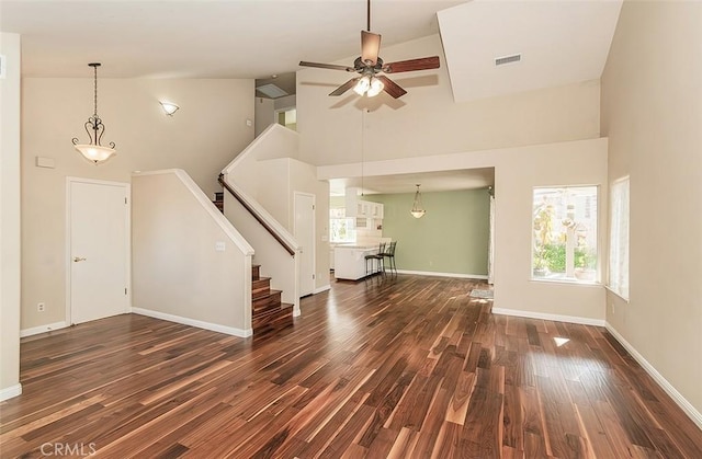 unfurnished living room featuring ceiling fan, dark hardwood / wood-style flooring, and high vaulted ceiling