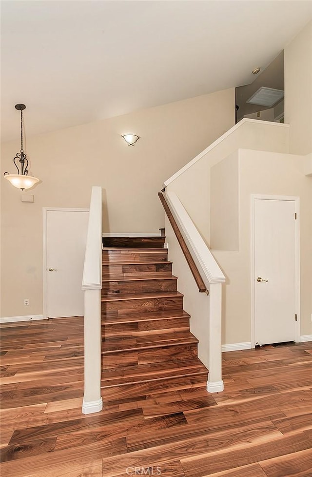 stairway featuring a high ceiling and wood-type flooring