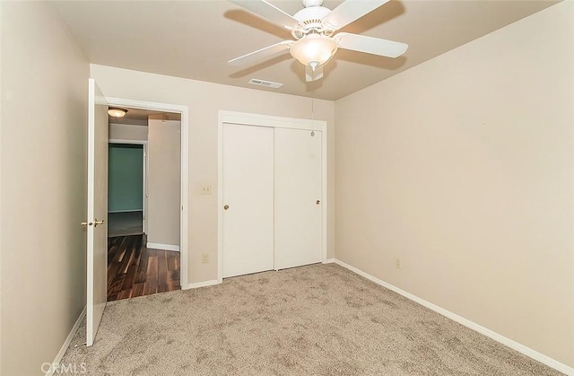 unfurnished bedroom featuring carpet floors, a closet, and ceiling fan