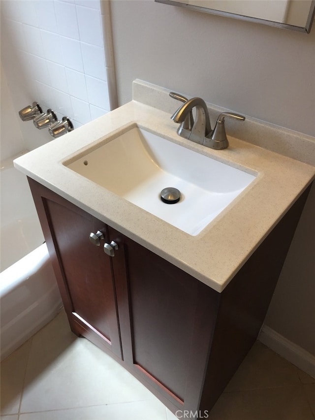 bathroom with tile patterned flooring, vanity, and a washtub