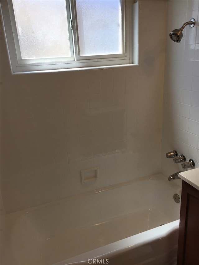 bathroom featuring vanity and tiled shower / bath