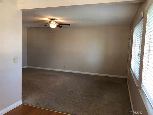 unfurnished room featuring a textured ceiling, dark wood-type flooring, and ceiling fan