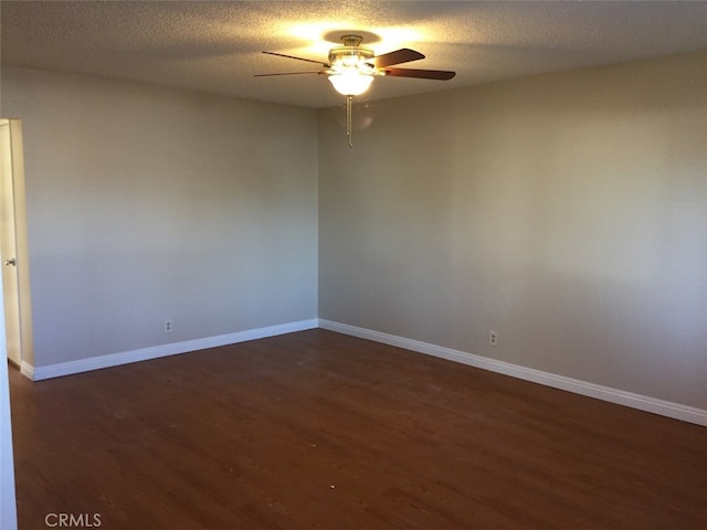 spare room with dark wood-type flooring, a textured ceiling, and ceiling fan