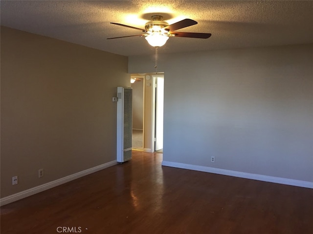 spare room featuring ceiling fan, dark hardwood / wood-style floors, and a textured ceiling