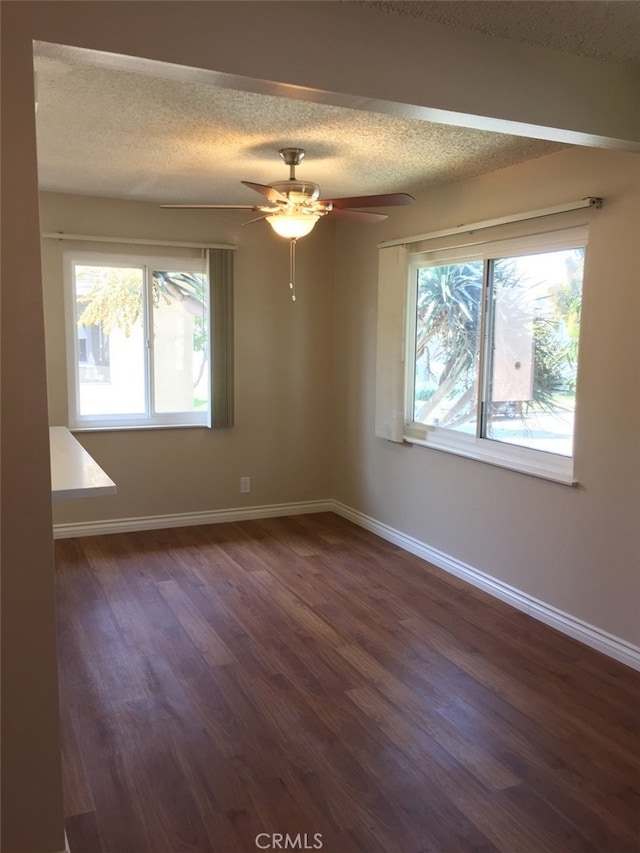 unfurnished room featuring ceiling fan, dark hardwood / wood-style floors, and a textured ceiling