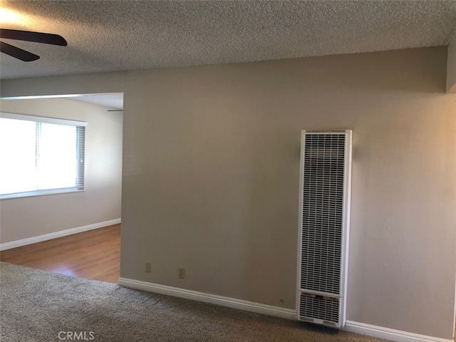 carpeted spare room featuring a textured ceiling and ceiling fan