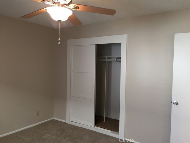 unfurnished bedroom with ceiling fan, carpet floors, and a closet