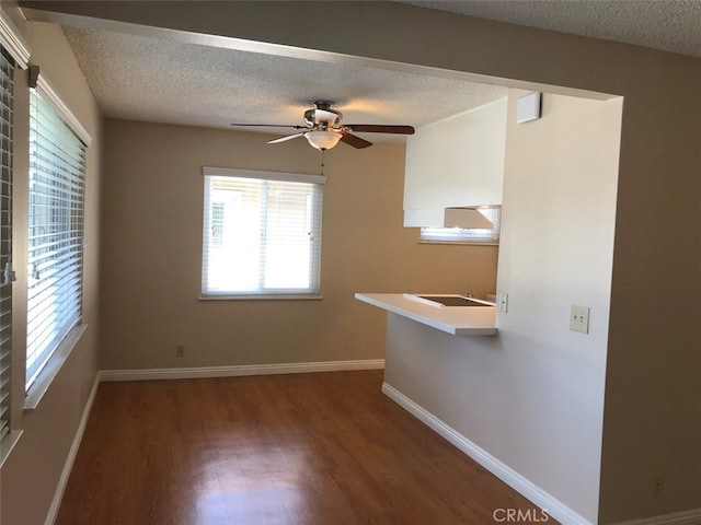 spare room featuring ceiling fan, dark hardwood / wood-style floors, and a textured ceiling