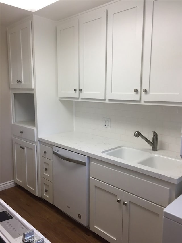 kitchen with tasteful backsplash, sink, white cabinets, white dishwasher, and dark wood-type flooring