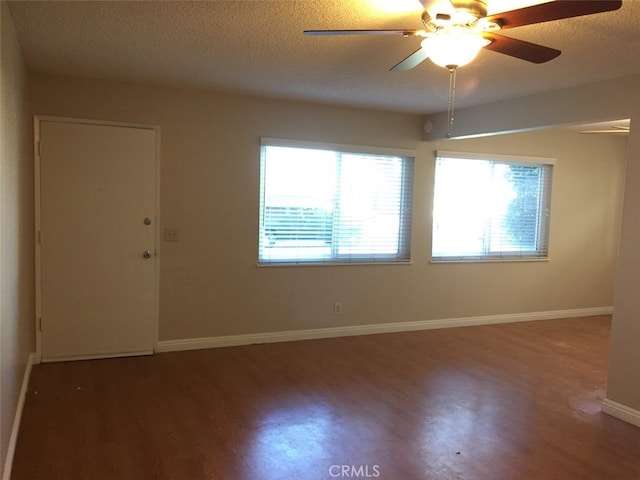 unfurnished room with dark hardwood / wood-style flooring, ceiling fan, and a textured ceiling