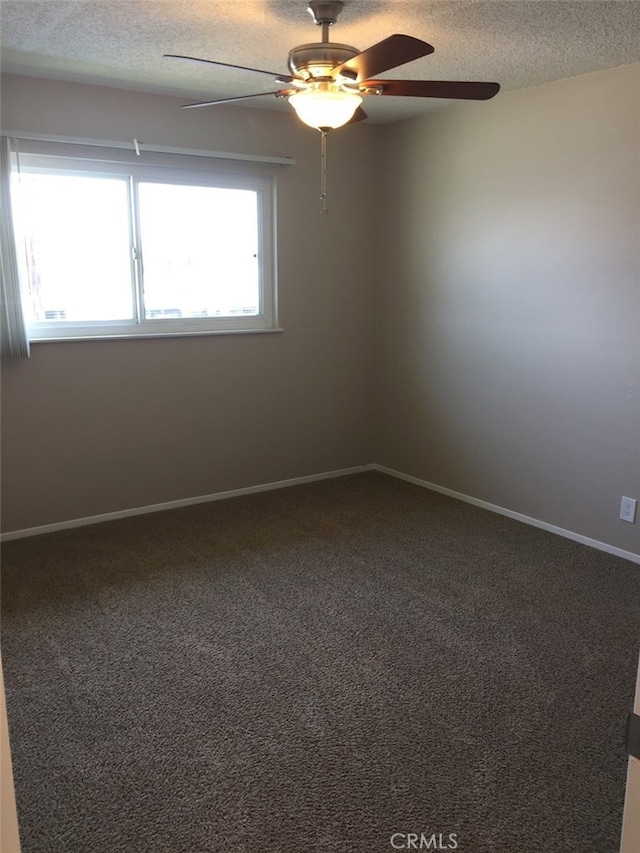 carpeted empty room featuring ceiling fan and a textured ceiling