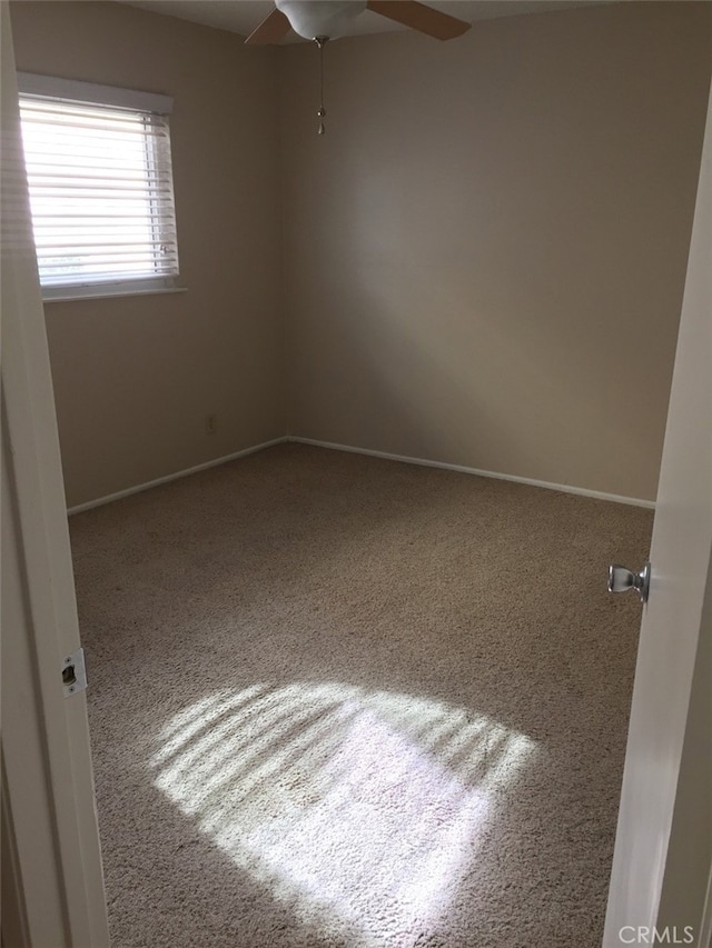 spare room featuring carpet floors and ceiling fan