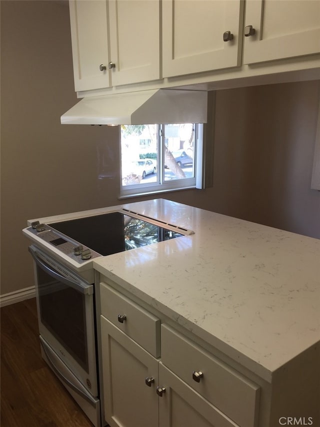 kitchen featuring light stone counters, white cabinetry, stainless steel electric stove, and dark wood-type flooring