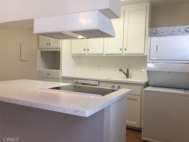 kitchen with a center island, tasteful backsplash, extractor fan, stacked washer / drying machine, and white cabinets