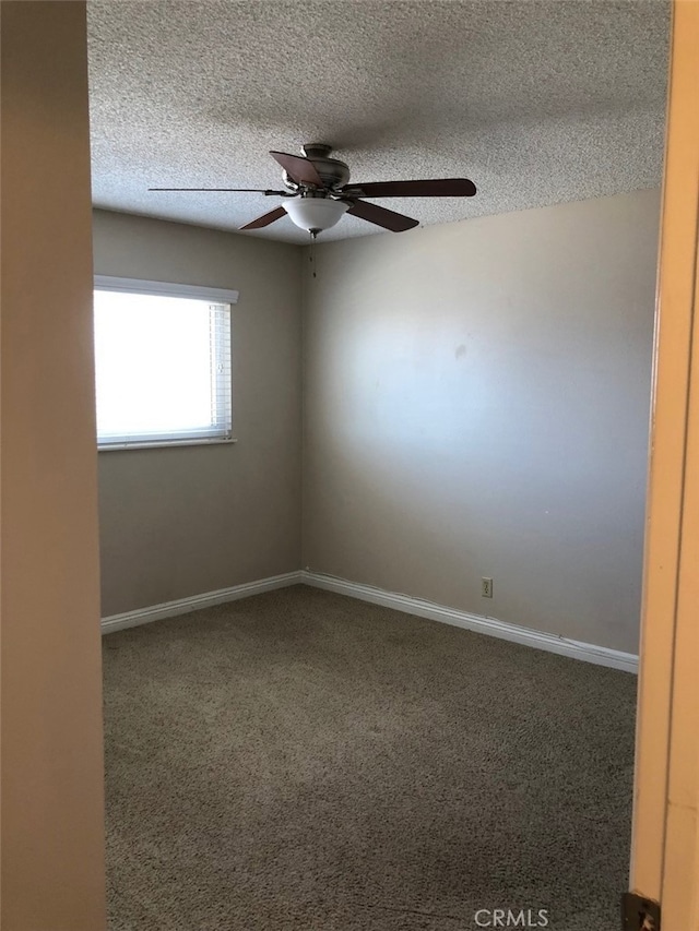 unfurnished room with ceiling fan, carpet, and a textured ceiling